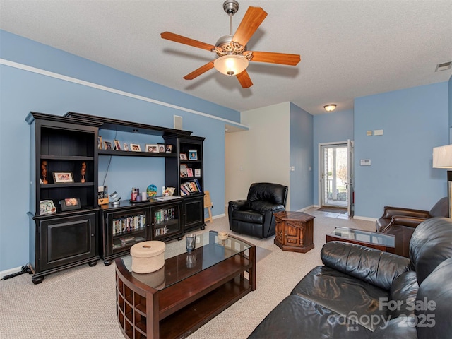 living area featuring a ceiling fan, baseboards, visible vents, a textured ceiling, and carpet flooring