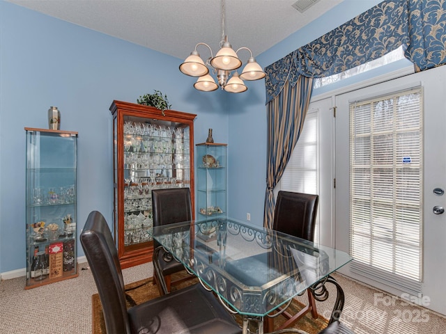 dining space with carpet flooring, a notable chandelier, baseboards, and a textured ceiling