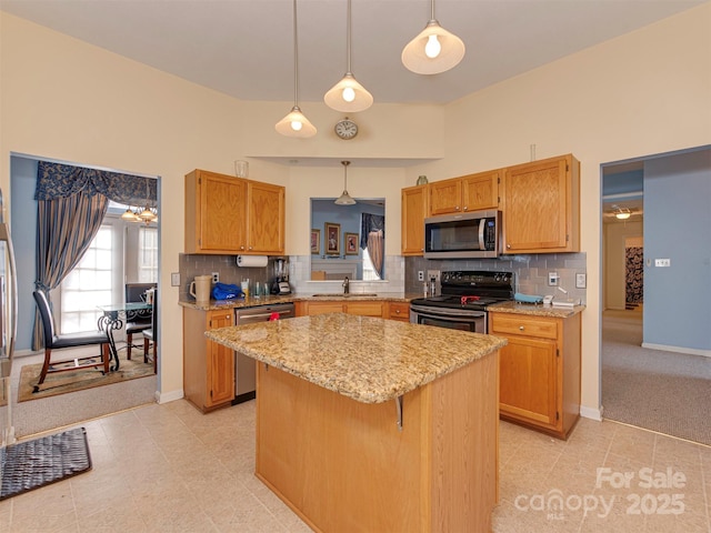 kitchen with a sink, decorative light fixtures, tasteful backsplash, a kitchen island, and stainless steel appliances