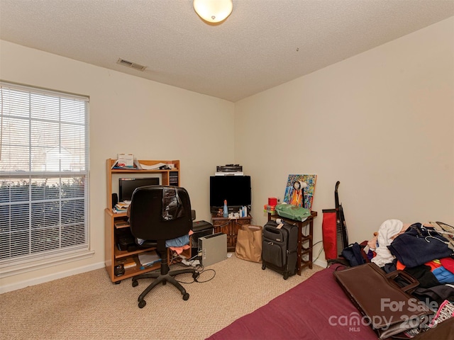 office area with visible vents, light colored carpet, and a textured ceiling