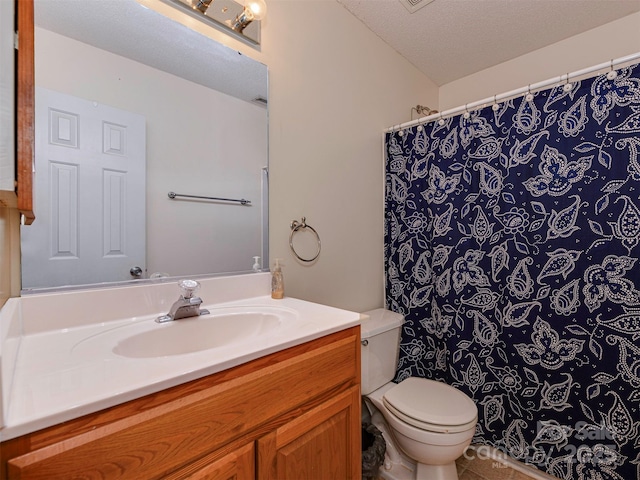 bathroom featuring a textured ceiling, toilet, and vanity