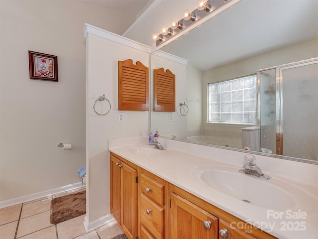 bathroom featuring double vanity, a shower stall, tile patterned floors, and a sink