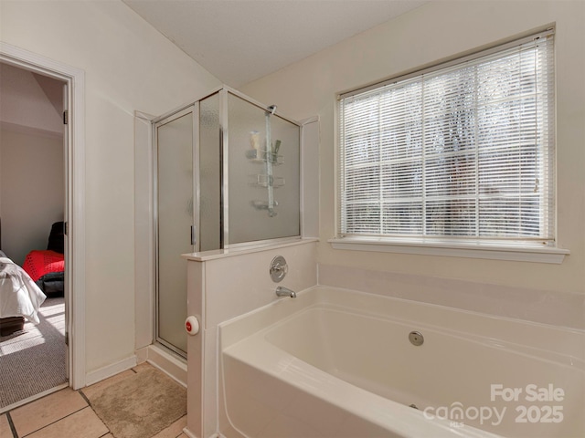 full bathroom featuring tile patterned floors, plenty of natural light, a stall shower, and ensuite bath