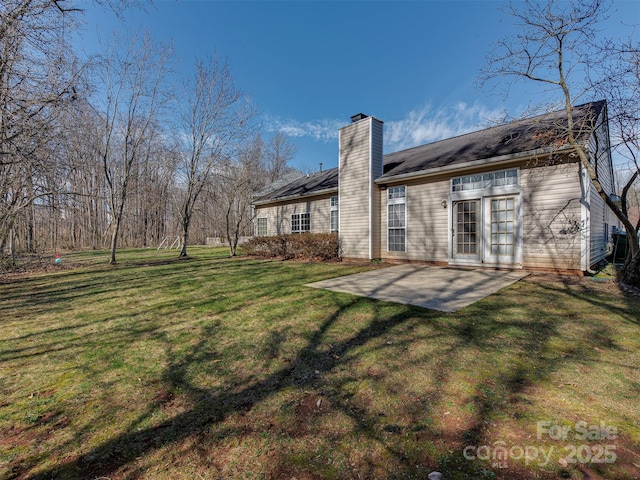 back of house with a patio area, a chimney, and a yard