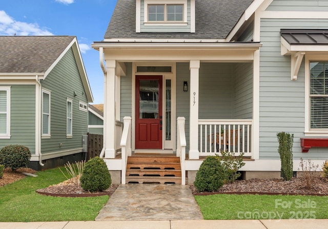 property entrance with covered porch and a shingled roof