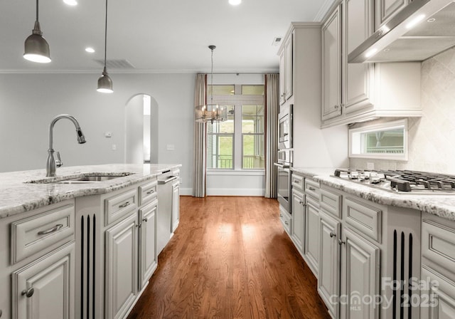 kitchen with visible vents, ornamental molding, a sink, stainless steel gas stovetop, and under cabinet range hood