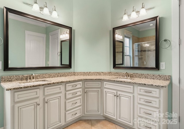 bathroom featuring a sink, double vanity, a stall shower, and crown molding