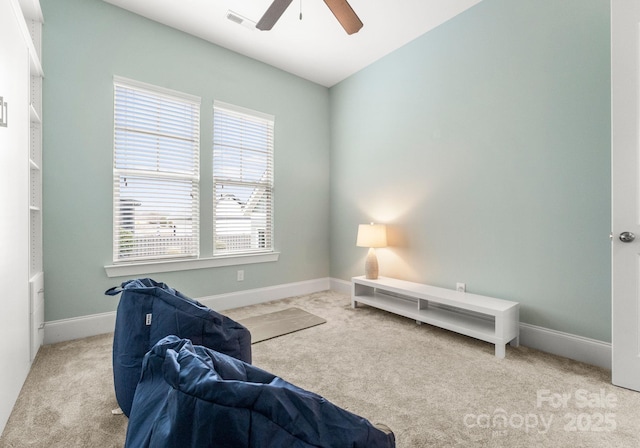 living area featuring baseboards, visible vents, carpet floors, and ceiling fan