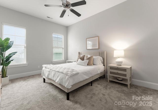 carpeted bedroom with visible vents, multiple windows, and baseboards