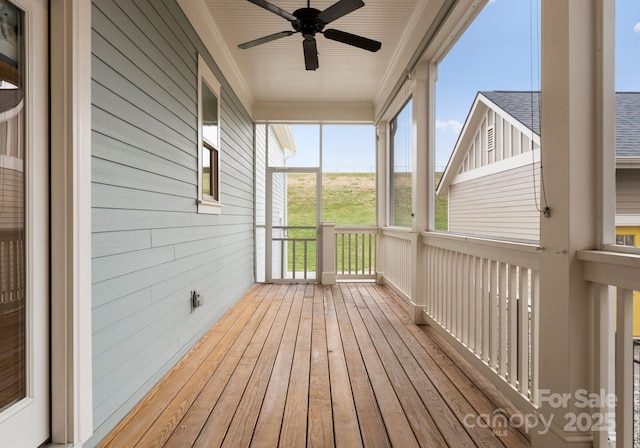 unfurnished sunroom featuring ceiling fan