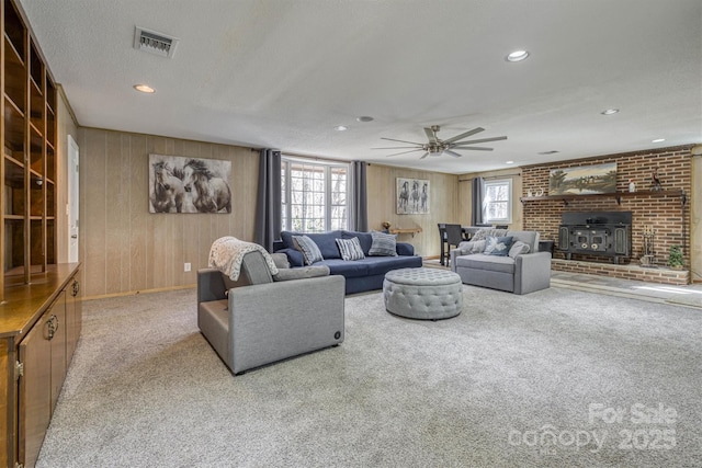 living area featuring visible vents, recessed lighting, wood walls, and carpet floors