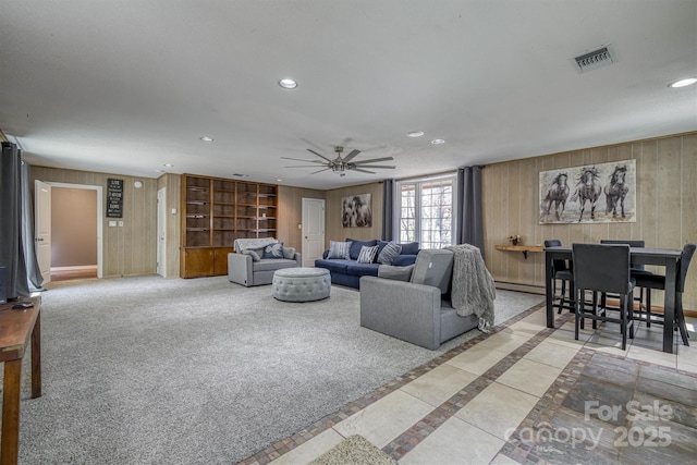 living area with wooden walls, visible vents, carpet floors, recessed lighting, and ceiling fan