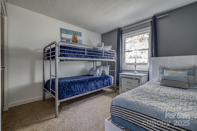 bedroom with a textured ceiling, baseboards, and carpet floors