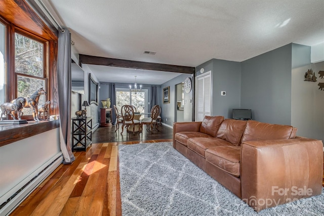 living area with visible vents, baseboards, a chandelier, wood finished floors, and a baseboard radiator