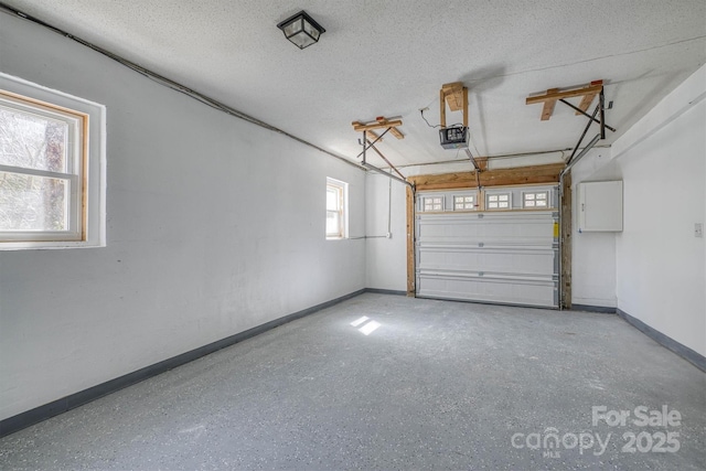 garage with a garage door opener and baseboards