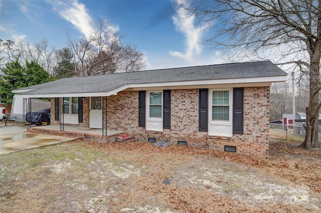 ranch-style home featuring a carport, fence, a shingled roof, crawl space, and brick siding