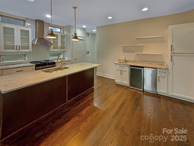 kitchen with a sink, range with gas cooktop, wall chimney range hood, refrigerator, and open shelves