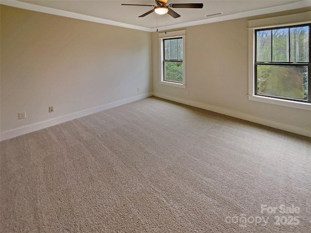 empty room featuring baseboards, visible vents, ceiling fan, ornamental molding, and light carpet