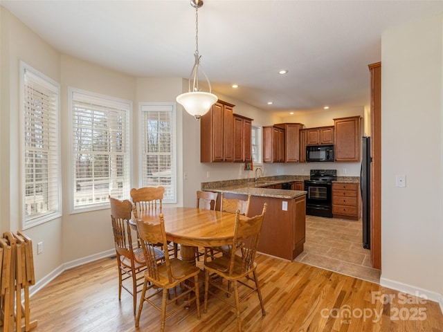 dining space with recessed lighting, baseboards, and light wood finished floors