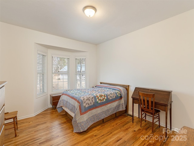 bedroom with light wood-type flooring and baseboards