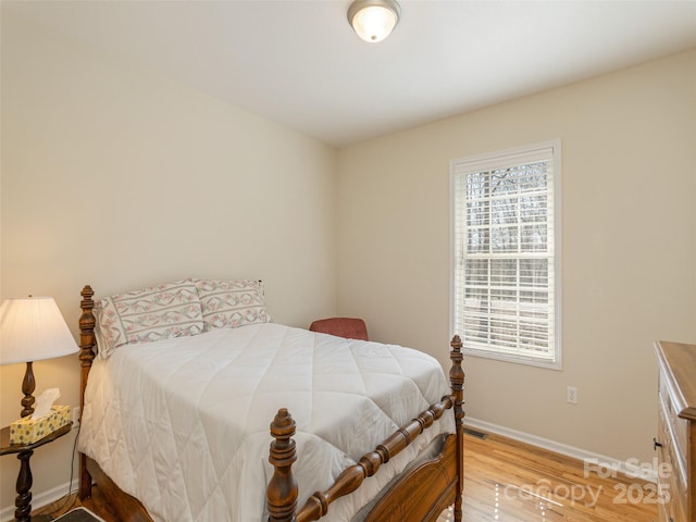 bedroom featuring visible vents, baseboards, and light wood-style floors