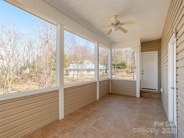 unfurnished sunroom featuring a ceiling fan