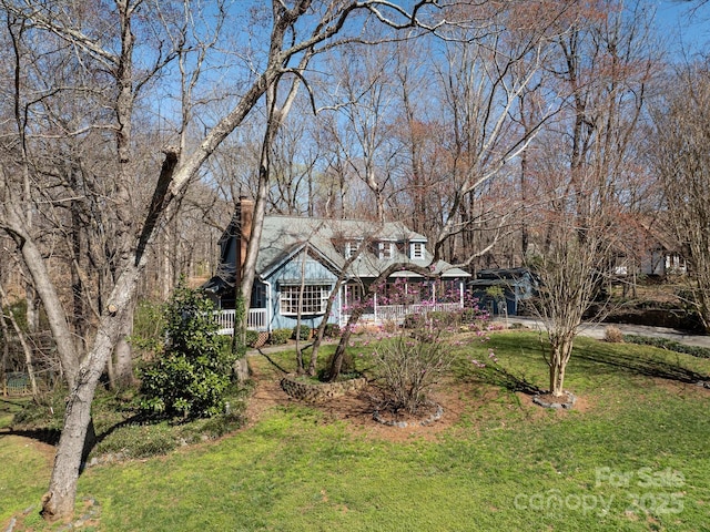 exterior space with a chimney and a front yard