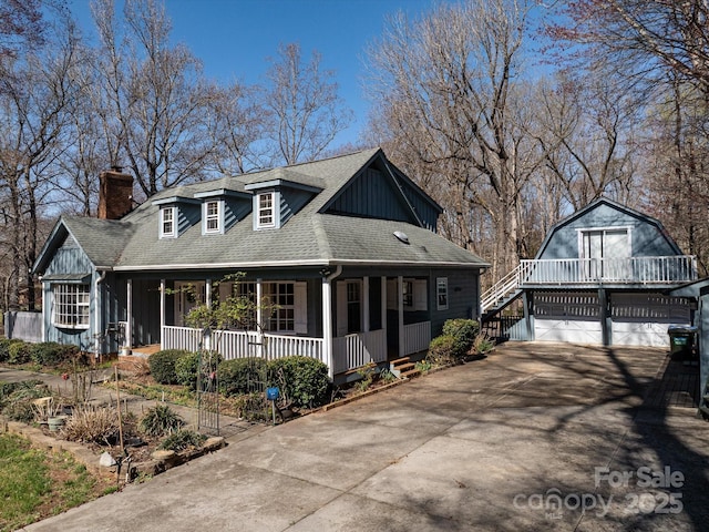 view of front of home featuring board and batten siding, a shingled roof, covered porch, a chimney, and driveway