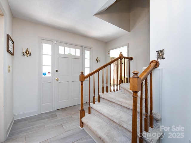 entrance foyer with baseboards and stairs