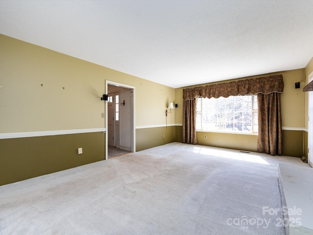 carpeted spare room featuring visible vents