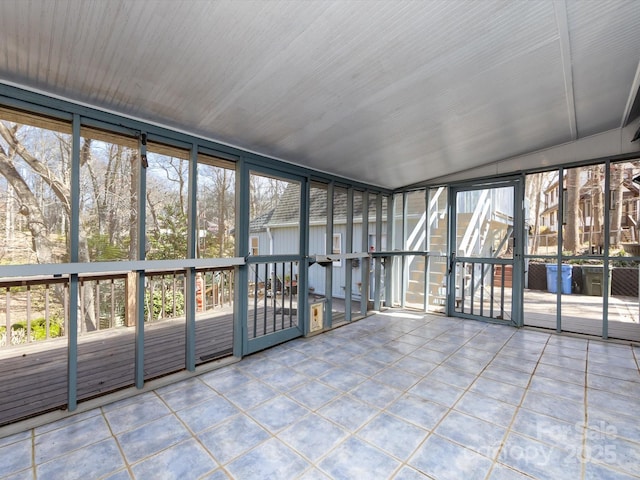 unfurnished sunroom featuring vaulted ceiling