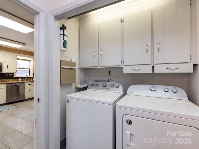 washroom featuring washer and clothes dryer, cabinet space, and a sink