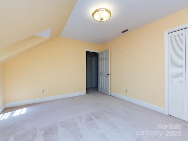 bonus room featuring visible vents, lofted ceiling, light colored carpet, and baseboards