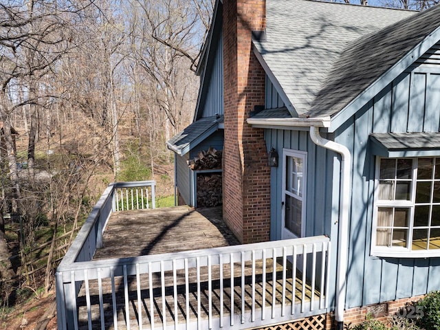 view of side of home with a chimney, board and batten siding, and a shingled roof