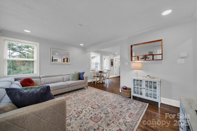 living area featuring recessed lighting, a healthy amount of sunlight, dark wood-type flooring, and baseboards