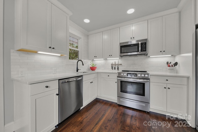 kitchen with light countertops, white cabinets, appliances with stainless steel finishes, and a sink