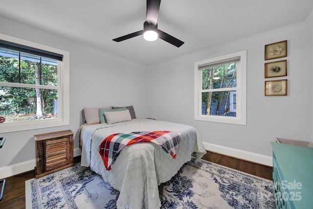 bedroom with a ceiling fan, wood finished floors, and baseboards