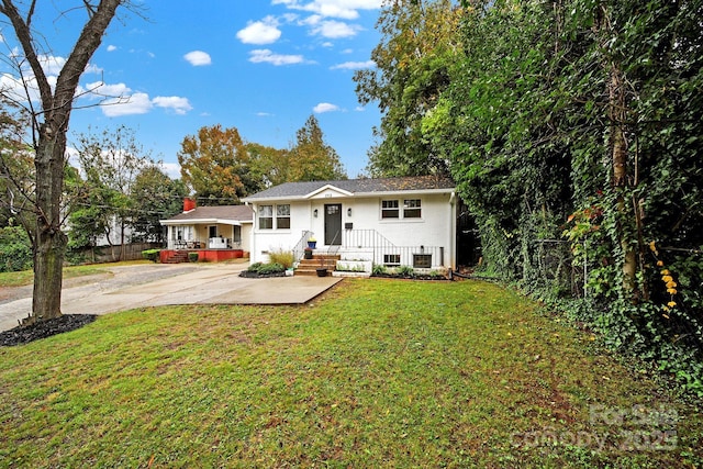 view of front of house with brick siding, a front lawn, and fence