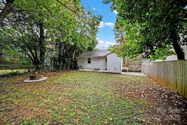 view of yard with a fenced backyard and an outdoor fire pit