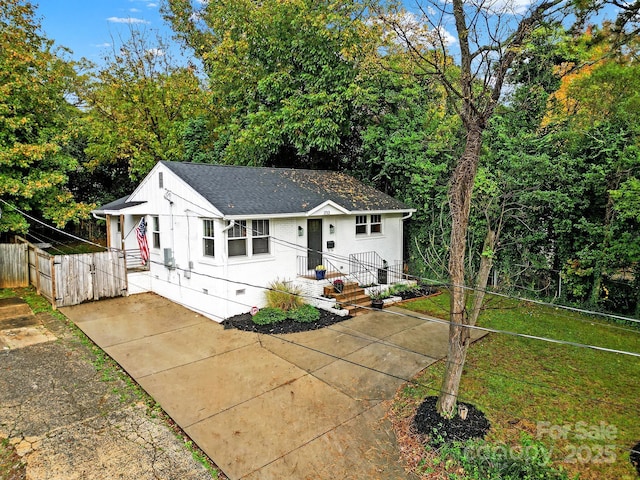 view of front facade with crawl space, a gate, fence, and a shingled roof