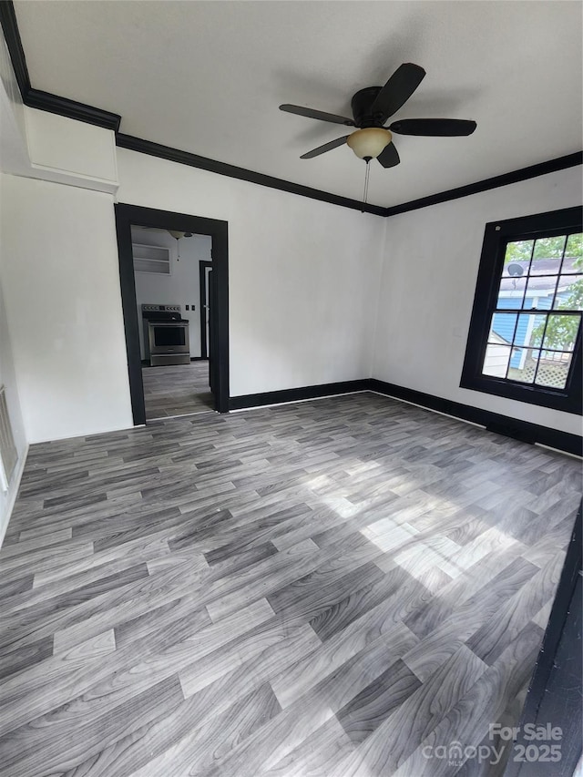 unfurnished room with ceiling fan, baseboards, and ornamental molding