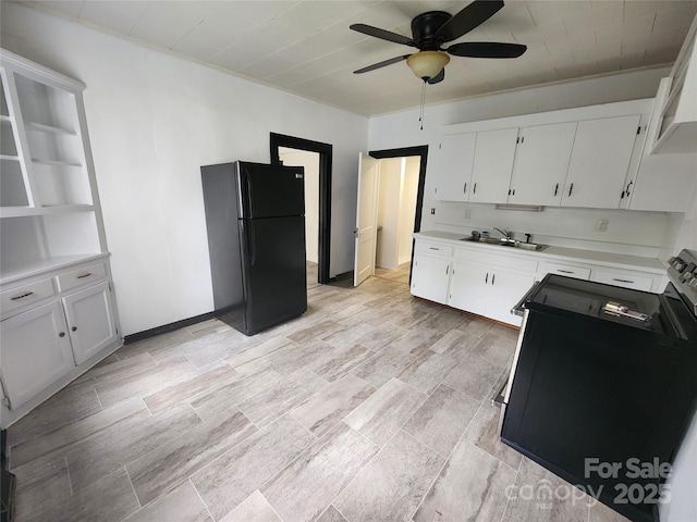 kitchen with electric stove, a sink, freestanding refrigerator, white cabinets, and light countertops