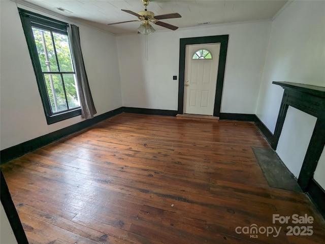 foyer entrance featuring hardwood / wood-style flooring, baseboards, visible vents, and ornamental molding