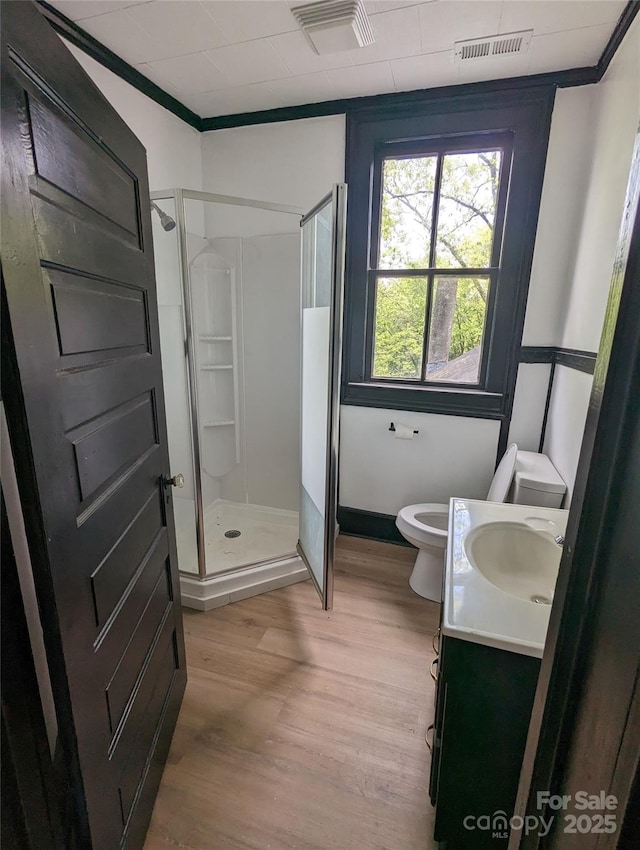 full bathroom with vanity, wood finished floors, visible vents, a shower stall, and toilet