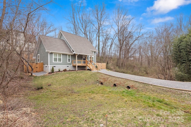 view of front of property with a front yard, driveway, a porch, a shingled roof, and crawl space