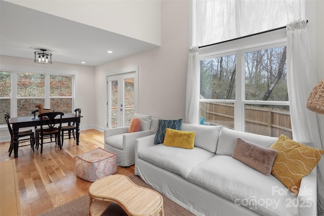 living room with recessed lighting, french doors, light wood-type flooring, and baseboards