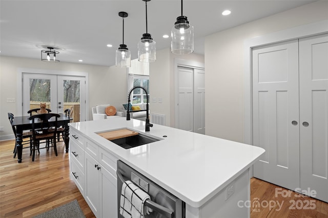 kitchen with light wood-style flooring, recessed lighting, a sink, french doors, and dishwasher