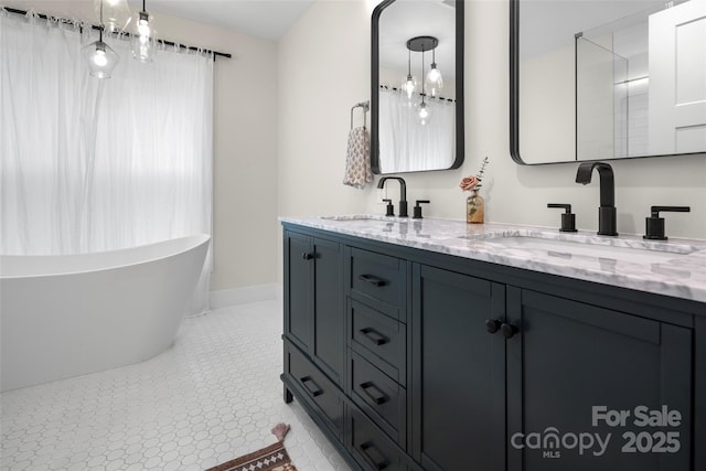 full bath with double vanity, a soaking tub, baseboards, and a sink