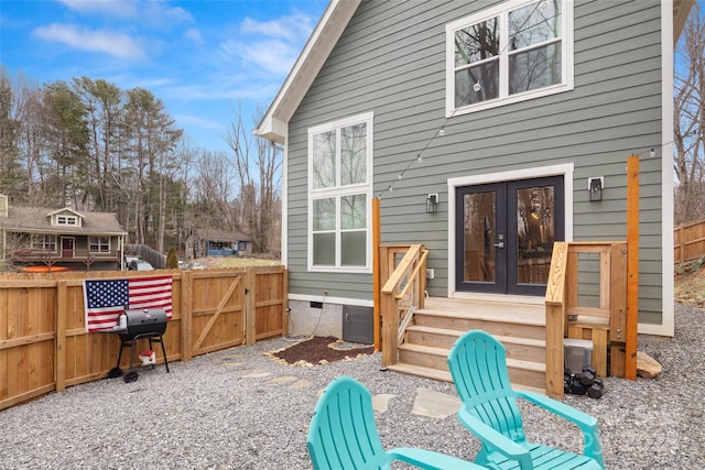 rear view of house featuring crawl space, french doors, fence, and a gate