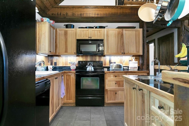 kitchen with light tile patterned flooring, light brown cabinets, black appliances, and a sink